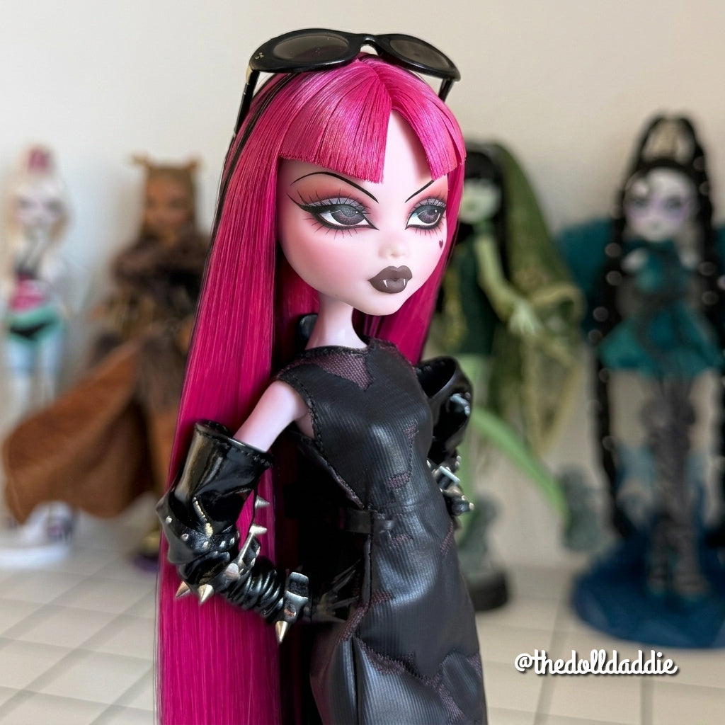 Three-quarter view close-up custom reroot example of Cerise Pink saran doll hair on Monster High Draculaura by @thedolldaddie. Detailed shot showcasing the smooth hair flow, blunt bangs, and dark lowlight contrast against her custom face paint.