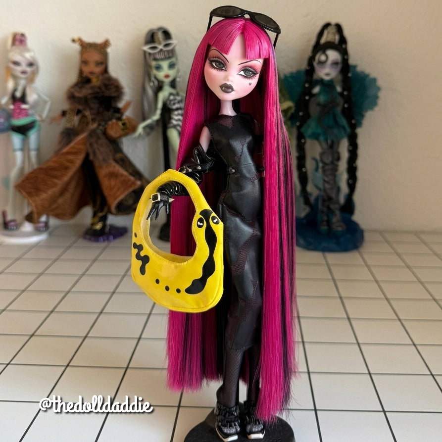 Full-body shot custom reroot example of Cerise Pink saran doll hair on Monster High Draculaura by @thedolldaddie. Full-length view displaying the floor-length rerooted hair styled with sunglasses, a black outfit, and a bright yellow shoulder bag.
