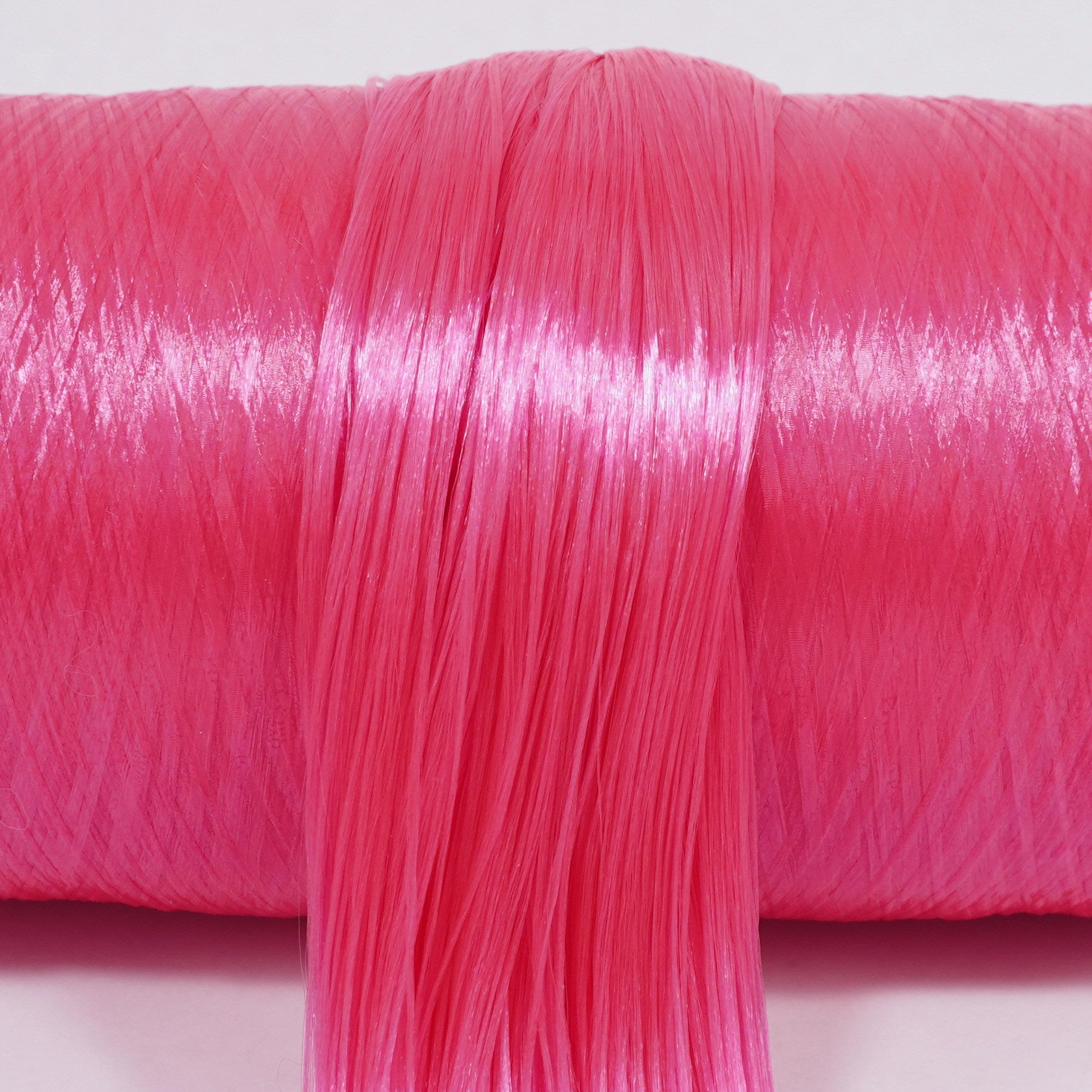 Cosmopolitan Pink nylon doll hair spool by Shimmer Locks. Perfect for Demon Hunter Mira customs! Smooth, vibrant cocktail-pink nylon fiber showing bright texture on the roll. 