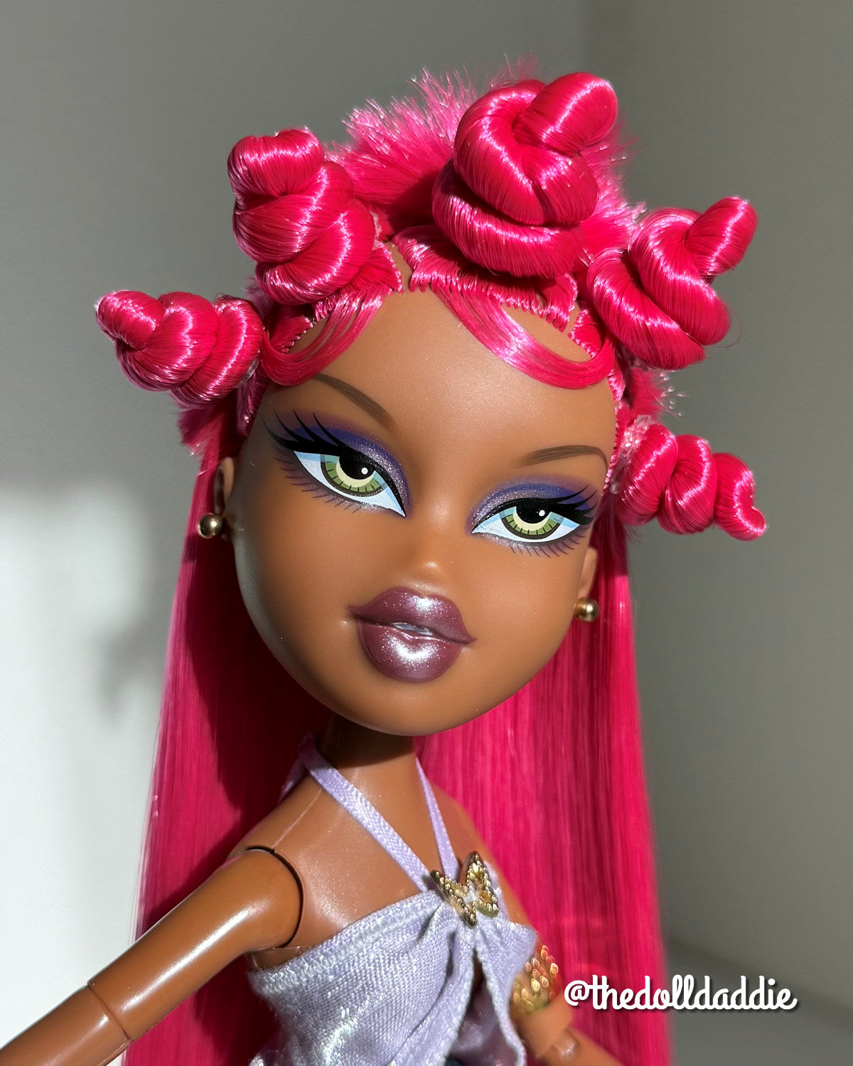 Close-up custom reroot example of Dragonfruit hot pink saran doll hair on Bratz Pop Starz Sasha by @thedolldaddie. Detailed shot highlighting the styled Bantu knots and hair color match.