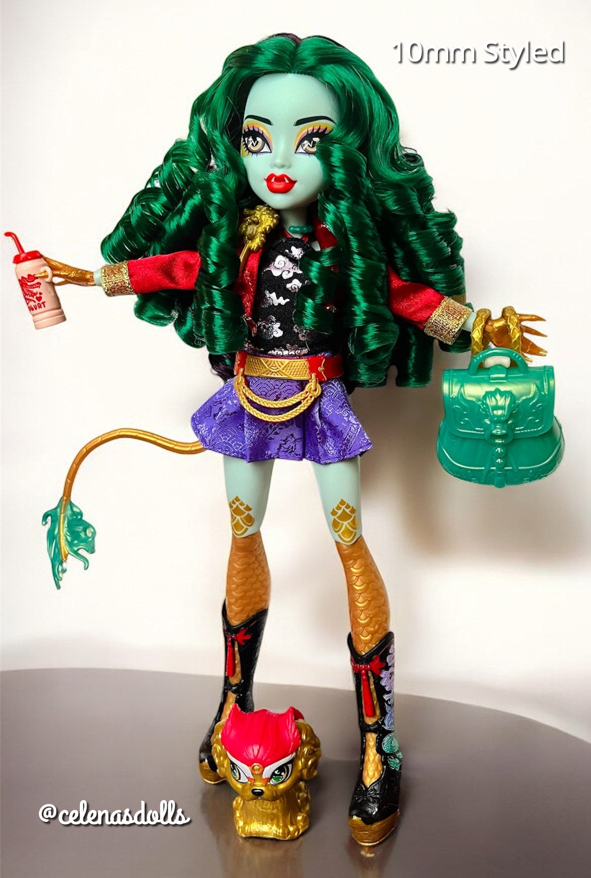 Full body shot of a Monster High G3 Jinafire Long doll restyled with a full head of voluminous emerald green curly nylon hair from Shimmer Locks.