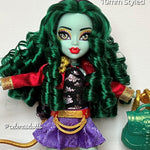 Monster High Jinafire Long doll displaying defined emerald green nylon hair curls from Shimmer Locks and styled with her original outfit and accessories.