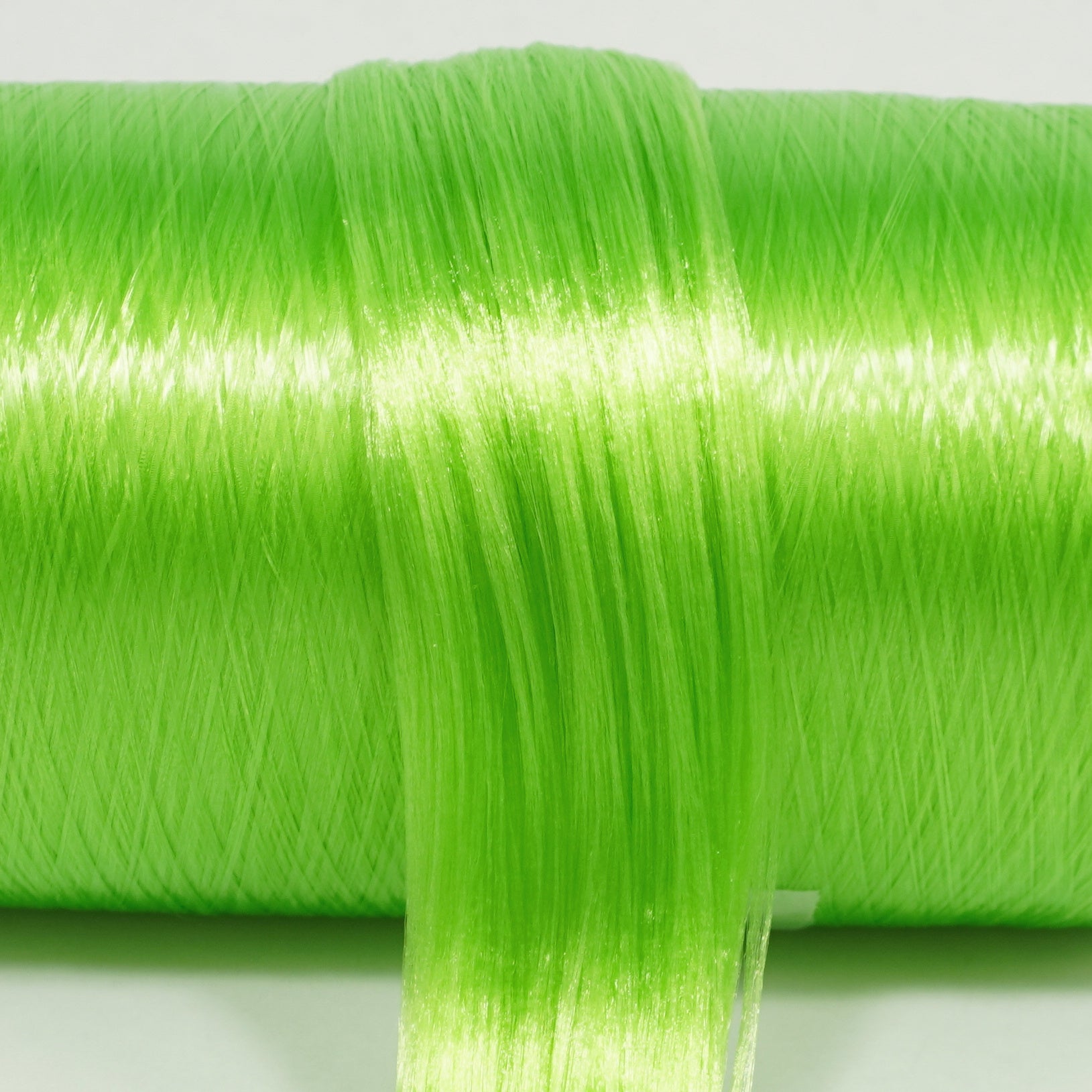 Funhouse Green nylon doll hair spool by Shimmer Locks. Smooth, bright lime green fiber on the roll, a touch lighter than Kiwi Tart.