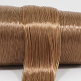 Iced Latte brown nylon doll hair spool showing the smooth texture and shine of the two-tone fiber on the roll