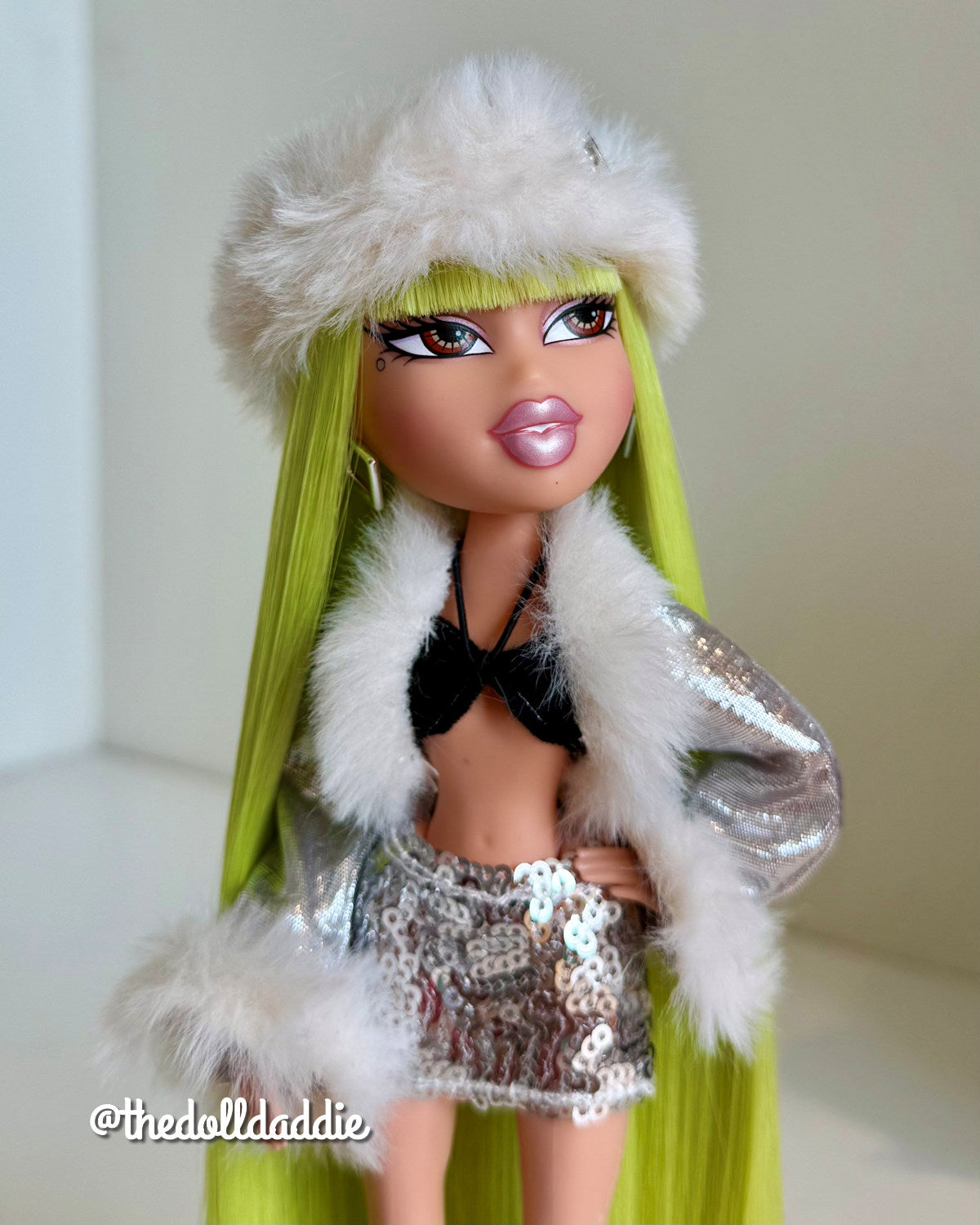 Mid-length outfit shot of custom Bratz Wintertime Wonderland Jade with Shimmer Locks Radioactive neon green saran doll hair rerooted by @thedolldaddie. Showcases hair length running down the sides of the silver sequin outfit.