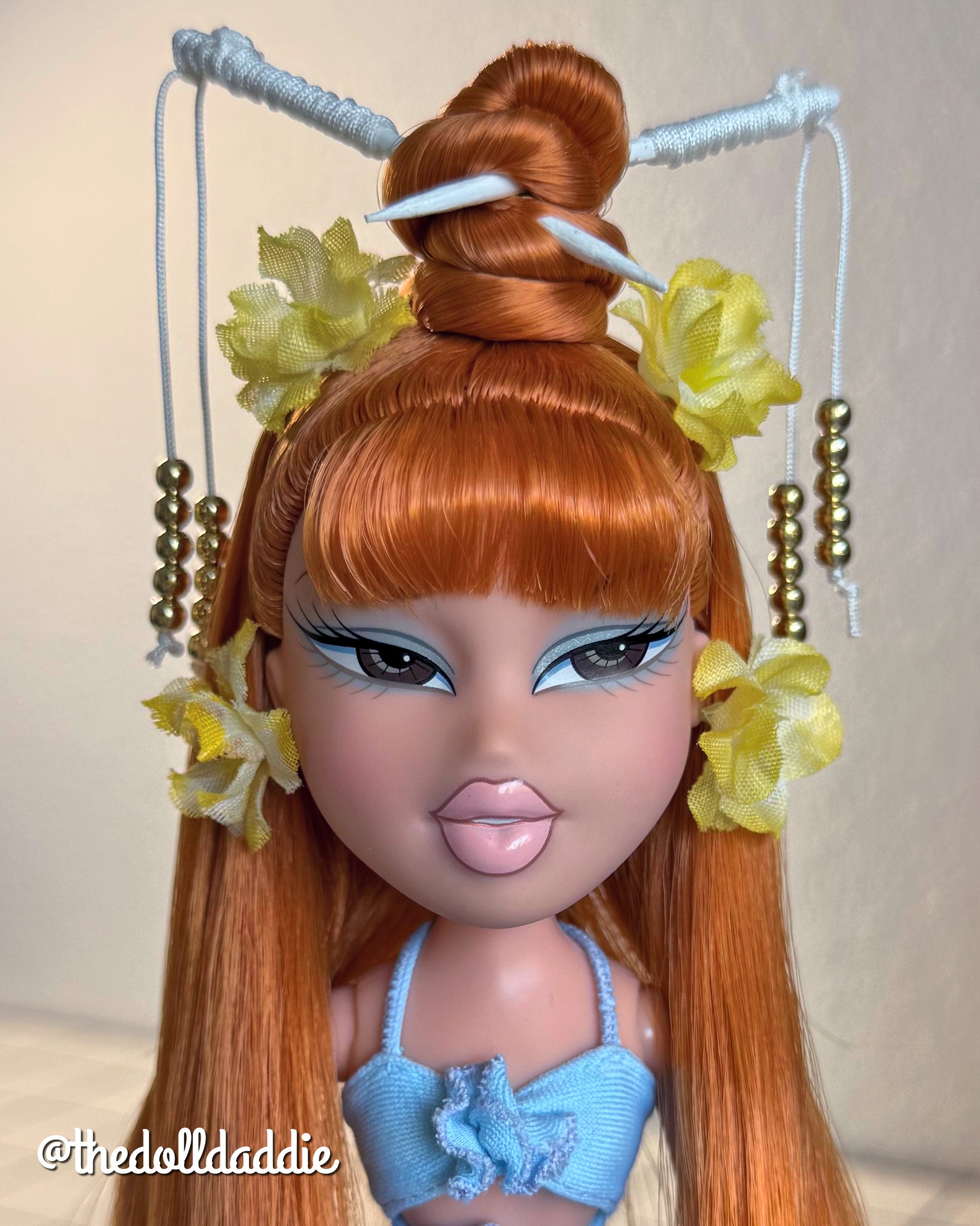 Extreme close-up custom reroot example of Safari Auburn saran doll hair on Bratz Pop Starz Jade by @thedolldaddie. Detailed portrait shot focusing on the smooth, blunt bangs, high topknot styling, and vibrant copper-red hair tone.
